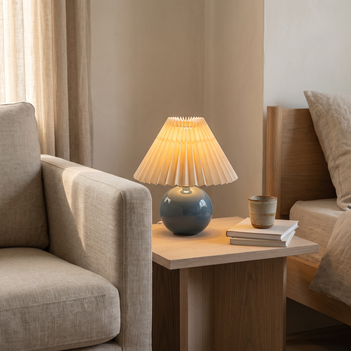 Ceramic table lamp with pleated shade on a side table