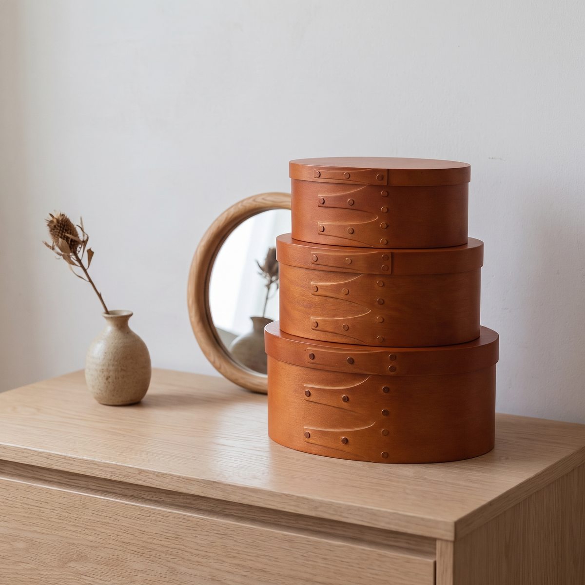 Stacked oval wooden boxes on a dresser
