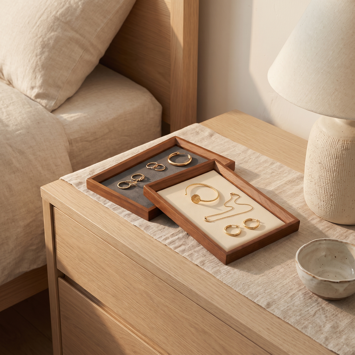 Velvet-lined wooden jewellery trays on a bedside table