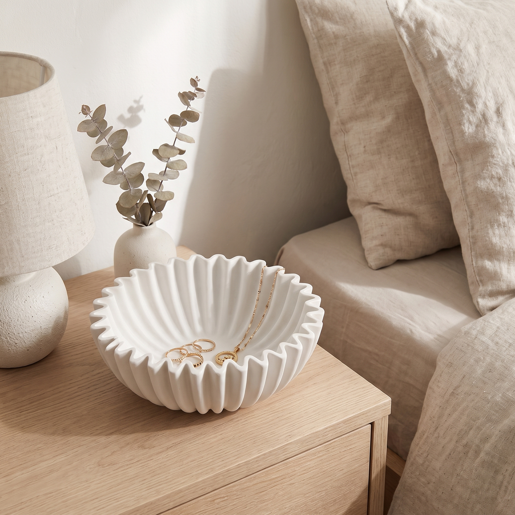 White scalloped lotus leaf bowl holding jewellery on a bedside table