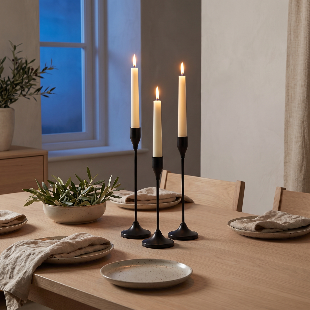 Black metal taper candle holders on a set dining table