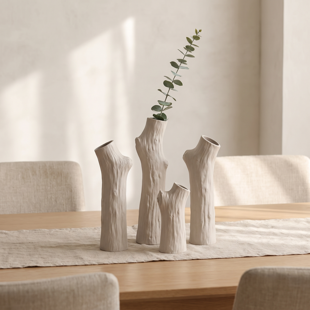 Tree trunk ceramic vases in three sizes on a dining table