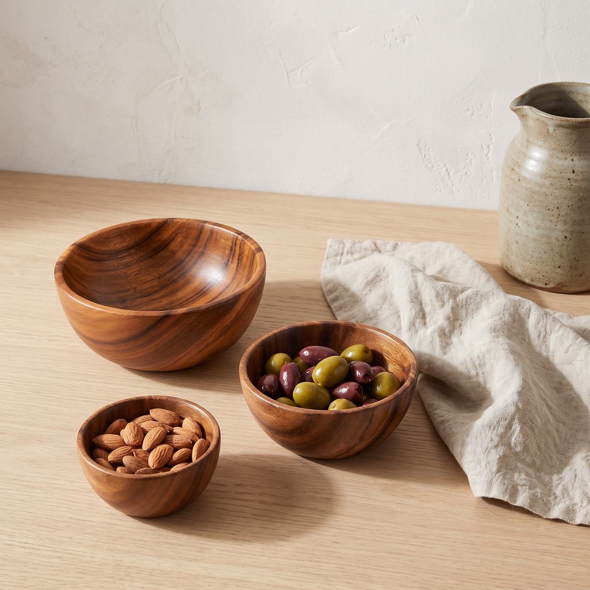 Small acacia wood serving bowls with almonds and olives